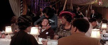 Movie still from “Lady Sings the Blues” (1972), directed by Sidney J. Furie – A group of people sitting at a table with food; Medium shot, Over the shoulder angle