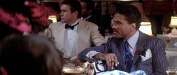 Movie still from “Lady Sings the Blues” (1972), directed by Sidney J. Furie – Two men sitting at a table in front of other people; Medium shot, Over the shoulder angle