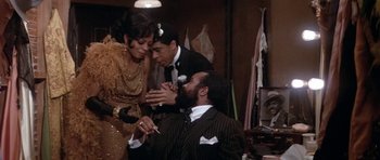 Movie still from “Lady Sings the Blues” (1972), directed by Sidney J. Furie – A group of people standing next to each other in a room; Medium shot, High angle