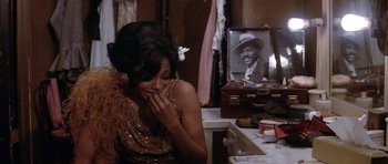 Movie still from “Lady Sings the Blues” (1972), directed by Sidney J. Furie – A woman sitting in front of a vanity next to a mirror; Medium shot, Over the shoulder angle