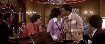 Movie still from “Lady Sings the Blues” (1972), directed by Sidney J. Furie – A man and a woman kissing in front of a piano; Medium shot, Over the shoulder angle