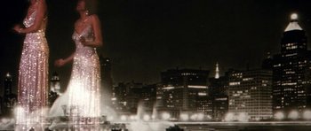 Movie still from “Lady Sings the Blues” (1972), directed by Sidney J. Furie – A woman standing in front of a city skyline at night; Wide shot, Low angle