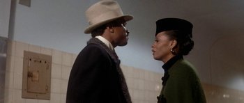 Movie still from “Lady Sings the Blues” (1972), directed by Sidney J. Furie – A man and a woman standing next to each other in front of a brick wall; Close Up shot, Low angle