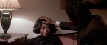 Movie still from “Lady Sings the Blues” (1972), directed by Sidney J. Furie – A woman getting her hair done by a man; Close Up shot, Over the shoulder angle