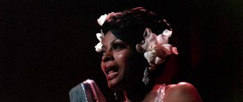 Movie still from “Lady Sings the Blues” (1972), directed by Sidney J. Furie – A woman in a white dress is holding a microphone; Close Up shot, Low angle