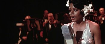 Movie still from “Lady Sings the Blues” (1972), directed by Sidney J. Furie – A woman singing in front of an orchestra; Close Up shot, Over the shoulder angle