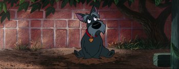 Movie still from “Lady and the Tramp” (1955), directed by Clyde Geronimi – A dog sitting on the ground in front of a brick wall; Wide shot, High angle