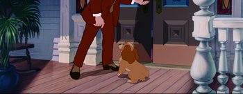 Movie still from “Lady and the Tramp” (1955), directed by Clyde Geronimi – A dog sitting next to a man in a suit; Medium shot, Over the shoulder angle