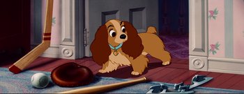 Movie still from “Lady and the Tramp” (1955), directed by Clyde Geronimi – A dog that is sitting on the ground; Medium shot, High angle