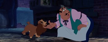 Movie still from “Lady and the Tramp” (1955), directed by Clyde Geronimi – A man and a dog are holding hands; Medium shot, Low angle