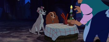 Movie still from “Lady and the Tramp” (1955), directed by Clyde Geronimi – Lady and the tramp sitting at a table with a lit candle; Wide shot, High angle