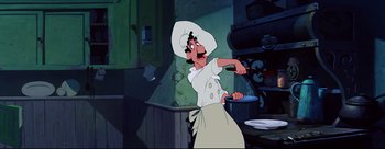 Movie still from “Lady and the Tramp” (1955), directed by Clyde Geronimi – A man in a chef's outfit holding a frying pan in front of an oven; Medium shot, Low angle