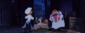 Movie still from “Lady and the Tramp” (1955), directed by Clyde Geronimi – A group of people standing around a table with a cake on it; Wide shot, Low angle