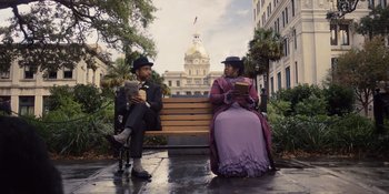 A man and a woman sitting on a wooden bench