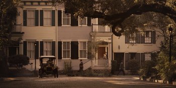 Two men are standing in front of a house