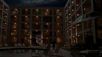 Movie still from “Lady in the Water” (2006), directed by M. Night Shyamalan – A person walking in front of a building at night; Extreme Wide shot, Low angle
