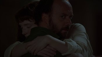 Movie still from “Lady in the Water” (2006), directed by M. Night Shyamalan – A man and a boy are hugging in a dark room; Close Up shot, Over the shoulder angle