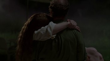 Movie still from “Lady in the Water” (2006), directed by M. Night Shyamalan – A man and a woman hugging in a dark room; Medium shot, Over the shoulder angle