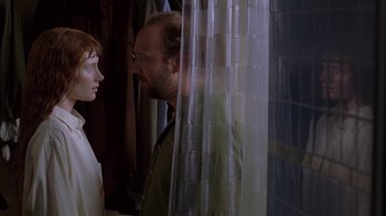 Movie still from “Lady in the Water” (2006), directed by M. Night Shyamalan – A man standing next to a woman in front of a curtain; Medium shot, Over the shoulder angle