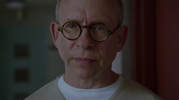 Movie still from “Lady in the Water” (2006), directed by M. Night Shyamalan – An older man wearing glasses and a white shirt; Close Up shot, Low angle