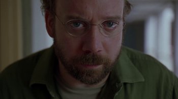 Movie still from “Lady in the Water” (2006), directed by M. Night Shyamalan – A person wearing glasses and a green shirt; Close Up shot, Low angle
