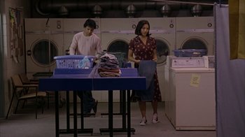 Movie still from “Lady in the Water” (2006), directed by M. Night Shyamalan – A man and a woman doing laundry in a laundromat; Wide shot, Low angle