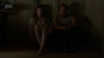 Movie still from “Lady in the Water” (2006), directed by M. Night Shyamalan – A man and a woman sitting next to each other on the floor; Medium shot, High angle