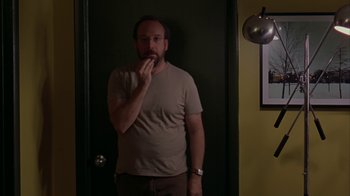Movie still from “Lady in the Water” (2006), directed by M. Night Shyamalan – A man standing next to a door in a room; Medium shot, Low angle