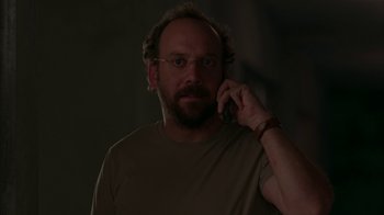 Movie still from “Lady in the Water” (2006), directed by M. Night Shyamalan – A man with a beard is talking on a cell phone; Medium shot, Low angle
