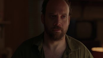 Movie still from “Lady in the Water” (2006), directed by M. Night Shyamalan – A person with a beard looking at the camera; Close Up shot, Over the shoulder angle