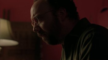 Movie still from “Lady in the Water” (2006), directed by M. Night Shyamalan – A person wearing glasses and a green shirt; Close Up shot, Over the shoulder angle