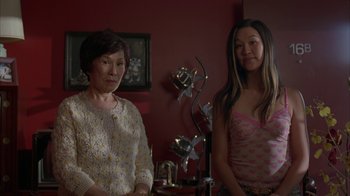 Movie still from “Lady in the Water” (2006), directed by M. Night Shyamalan – Two women standing next to each other in front of a red wall; Medium shot, Low angle