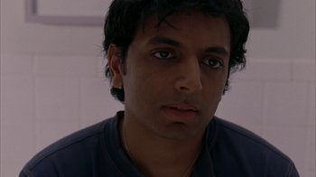 Movie still from “Lady in the Water” (2006), directed by M. Night Shyamalan – A person wearing a blue t - shirt; Close Up shot, High angle