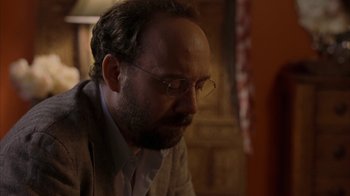 Movie still from “Lady in the Water” (2006), directed by M. Night Shyamalan – A man with a beard wearing glasses and a jacket; Close Up shot, Over the shoulder angle