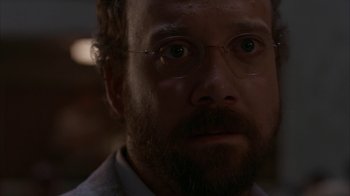 Movie still from “Lady in the Water” (2006), directed by M. Night Shyamalan – A person with a beard wearing glasses; Close Up shot, Over the shoulder angle