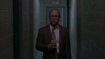 Movie still from “Lady in the Water” (2006), directed by M. Night Shyamalan – A man in a suit and tie holding a cell phone; Medium shot, Low angle