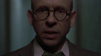 Movie still from “Lady in the Water” (2006), directed by M. Night Shyamalan – An older man wearing glasses and a suit; Close Up shot, Low angle