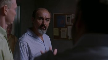 Movie still from “Lady in the Water” (2006), directed by M. Night Shyamalan – An older man with a beard is talking to a younger man; Close Up shot, Over the shoulder angle