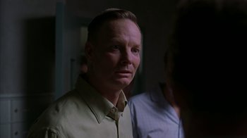 Movie still from “Lady in the Water” (2006), directed by M. Night Shyamalan – A person wearing a button up shirt; Close Up shot, Over the shoulder angle