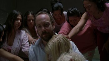 Movie still from “Lady in the Water” (2006), directed by M. Night Shyamalan – A group of people gathered around a man with a beard; Medium shot, High angle