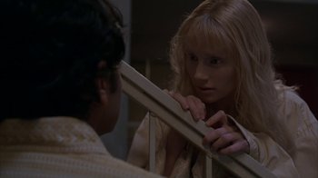 Movie still from “Lady in the Water” (2006), directed by M. Night Shyamalan – A woman holding onto a rail while a man looks on; Close Up shot, Low angle