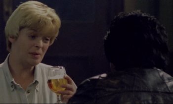 Movie still from “Ladybird Ladybird” (1994), directed by Ken Loach – A woman holding a glass of wine in front of another woman; Close Up shot, Over the shoulder angle