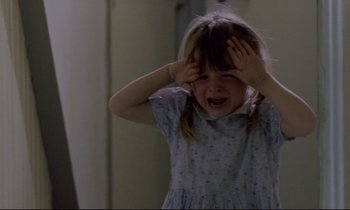 Movie still from “Ladybird Ladybird” (1994), directed by Ken Loach – A little girl is holding her hands to her face; Close Up shot, High angle