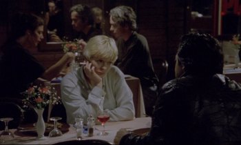 Movie still from “Ladybird Ladybird” (1994), directed by Ken Loach – A group of people sitting at a table with drinks; Medium shot, Over the shoulder angle
