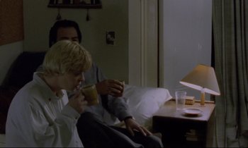 Movie still from “Ladybird Ladybird” (1994), directed by Ken Loach – Two people sitting in a living room drinking coffee; Medium shot, Over the shoulder angle