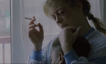 Movie still from “Ladybird Ladybird” (1994), directed by Ken Loach – A woman is holding a cigarette in her hand; Close Up shot, High angle