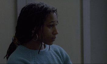 Movie still from “Ladybird Ladybird” (1994), directed by Ken Loach – A woman with dreadlocks is sitting in a room; Close Up shot, Over the shoulder angle