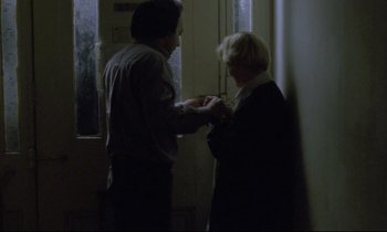 Movie still from “Ladybird Ladybird” (1994), directed by Ken Loach – A man and a woman standing next to each other in front of a door; Medium shot, Over the shoulder angle