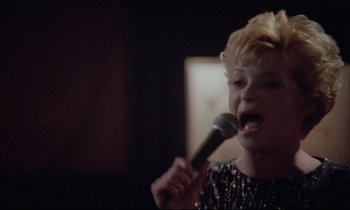 Movie still from “Ladybird Ladybird” (1994), directed by Ken Loach – A woman holding a microphone in her hand; Close Up shot, High angle