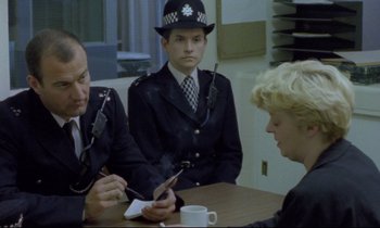 Movie still from “Ladybird Ladybird” (1994), directed by Ken Loach – A group of people sitting around a table; Medium shot, Over the shoulder angle